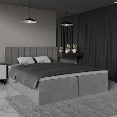 A modern bedroom with a large grey upholstered bed.