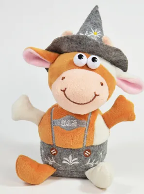 A plush toy cow wearing a traditional hat and lederhosen, sitting against a white background.