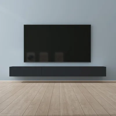 A modern living room setup with a wall-mounted television and a low cabinet.
