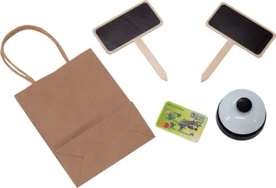 A collection of items for a play shop, including a paper bag, two small chalkboards, a credit card, and a bell.