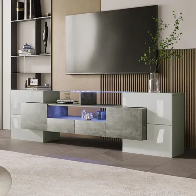 A modern living room setup featuring a large television mounted above a sleek, low TV cabinet with integrated LED lighting.