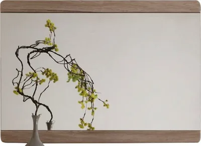 A decorative branch with yellow flowers in a vase, placed on a shelf.
