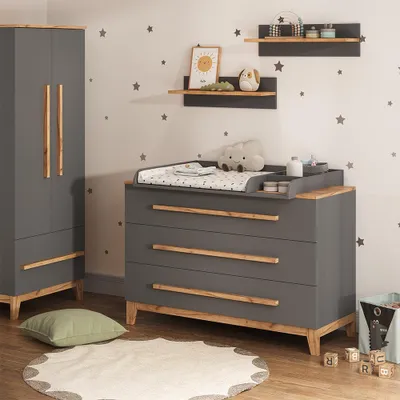 A nursery room with a changing table and wardrobe.