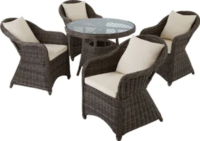 A rattan dining set with a glass-top table and four chairs, presented on a white background.