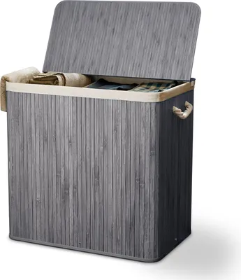 A grey bamboo laundry basket with a lid and beige lining, containing folded laundry.