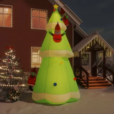 An inflatable Christmas tree with LED lights and decorations is set up in a snowy yard in front of a house.