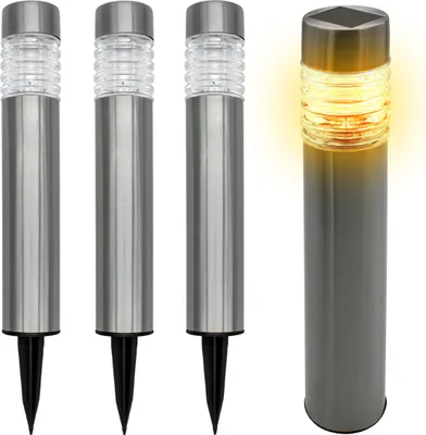 Four stainless steel solar garden lights on a white background. Three are unlit and one is lit with a yellow glow.