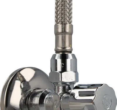 A close-up view of a chrome-plated angle valve with a braided hose attached.