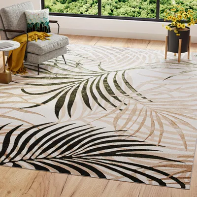 A living room scene with a rug, armchair, and plant.
