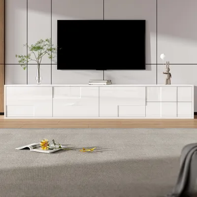 A modern white TV stand with a large black TV mounted above it, set in a clean, minimalist room.