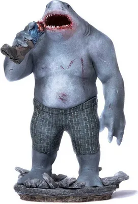 A statue of King Shark from The Suicide Squad, holding a severed limb.
