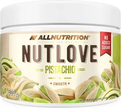 A jar of pistachio cream with pistachios scattered around it.