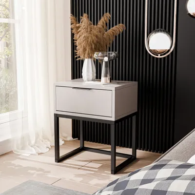 A modern bedroom setting with a nightstand next to a window and a bed.