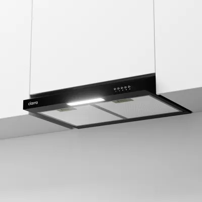 A black range hood is installed under white kitchen cabinets.