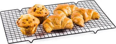 Muffins and croissants on a cooling rack.