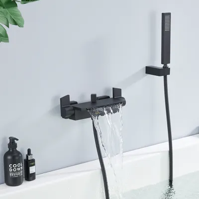 A black waterfall faucet and showerhead are mounted on a light gray wall above a white bathtub. There are two black bottles on the edge of the tub.