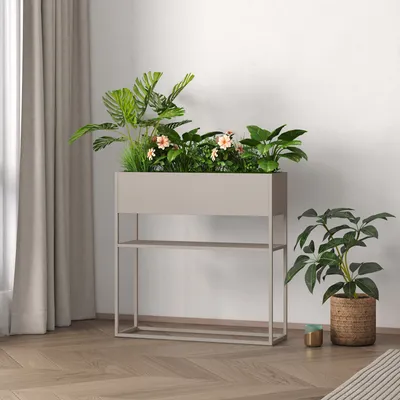 A planter with plants and flowers on a stand, next to a potted plant, in a room with curtains and wooden flooring.