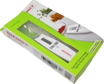 A digital kitchen scale in its packaging, with a clear window showing the product.