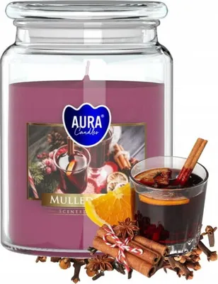 A large scented candle in a glass jar with a label depicting mulled wine and spices, with a glass of mulled wine and spices in the foreground.