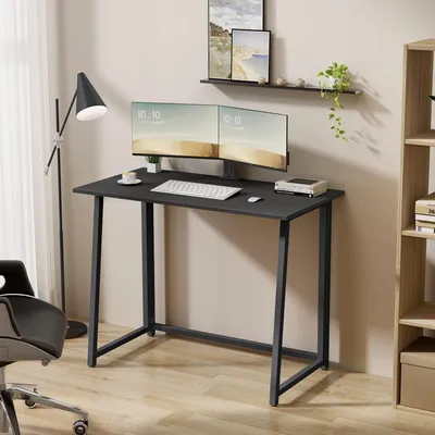 A modern home office setup with a black desk, dual monitors, and a black desk chair.