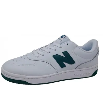 A white New Balance sneaker with green accents, shown from the side against a white background.