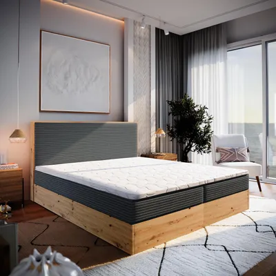 A bedroom scene with a large bed, artwork, and a window overlooking the ocean.
