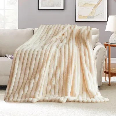 A plush blanket draped over a sofa in a living room setting.