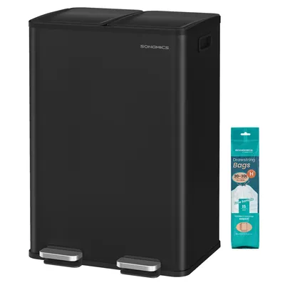 A black dual-compartment trash can with silver pedals, next to a package of trash bags.