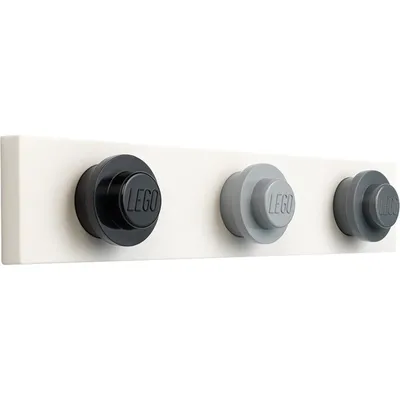 A white rack with three LEGO-themed knobs as hooks.
