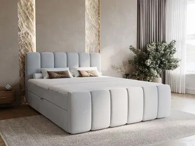 A modern bedroom with a light blue upholstered boxspring bed.