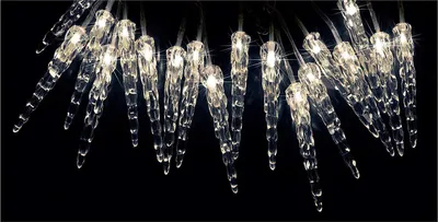 A string of illuminated icicle-shaped lights against a black background.