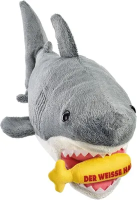 A plush toy shark with a yellow object in its mouth.