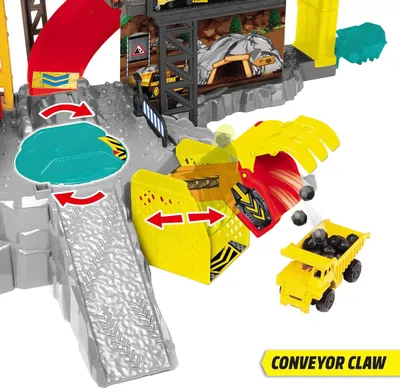 A toy construction site playset with a conveyor belt, claw, and dump truck.