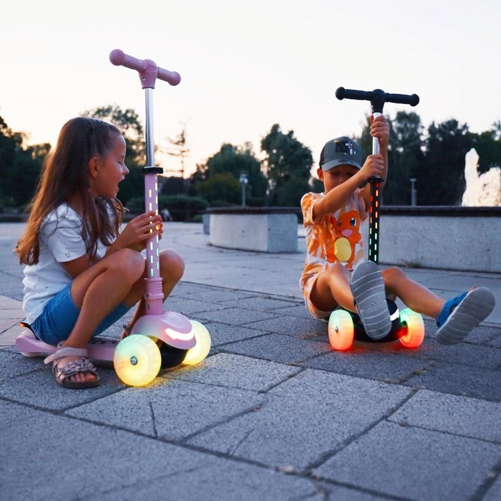 Twee kinderen spelen samen met de steps buiten.