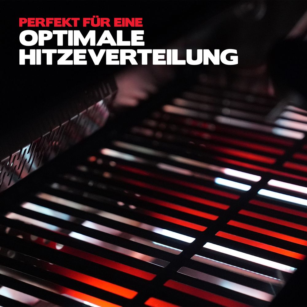 Brennende Hauptbrenner in einem Gasgrill unter einem Gusseisenrost bei Nacht