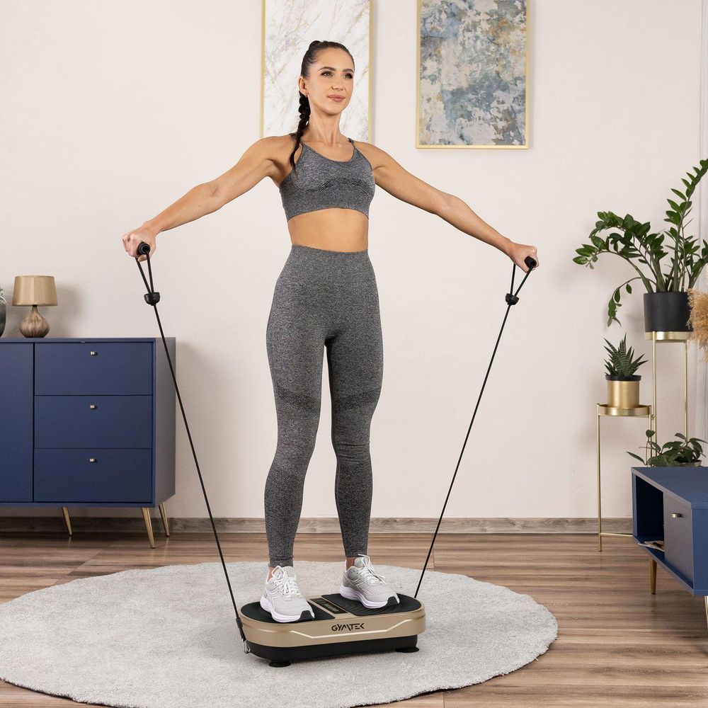 Frau trainiert mit der Vibrationsplatte und schwarzen Expanderbändern