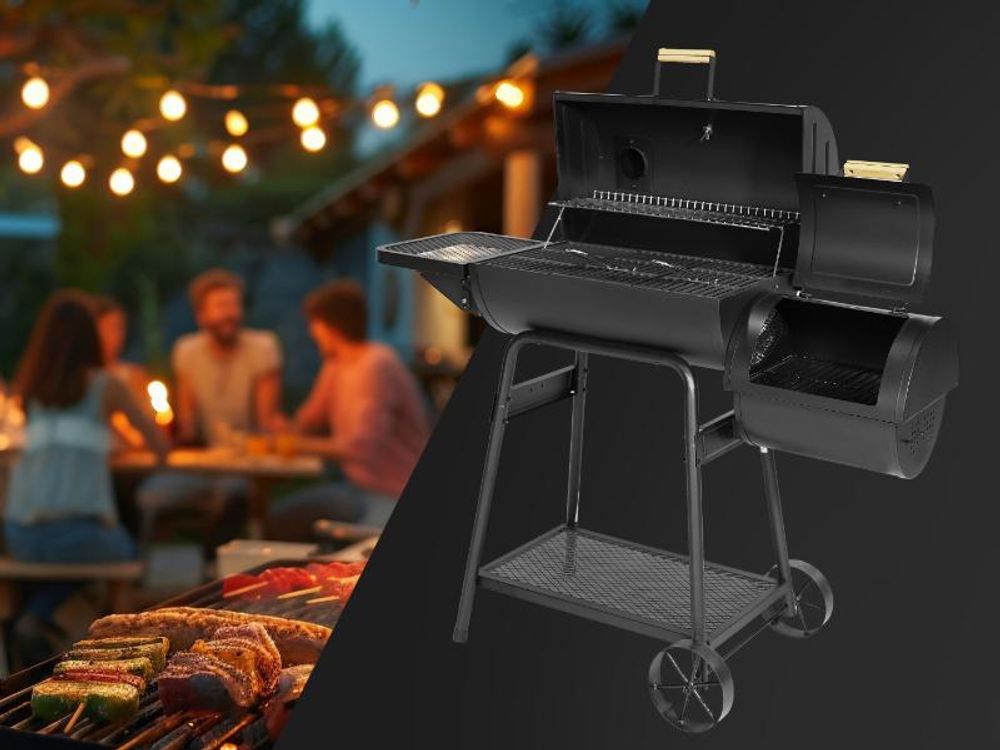 Der TAINO KAMAYO mit geöffneten Deckeln in Schrägansicht, im Hintergrund eine Gartenparty.