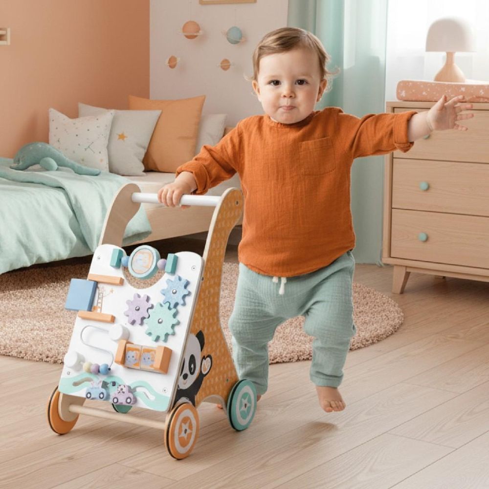 Kind loopt met houten duwwagen in kinderkamer