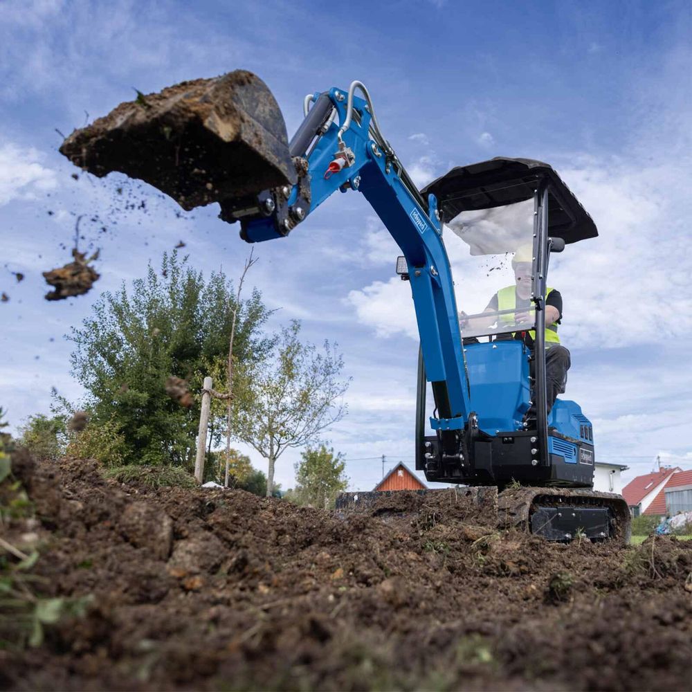 Das Bild zeigt eine Person bei der Arbeit mit dem Mini Bagger von Scheppach.