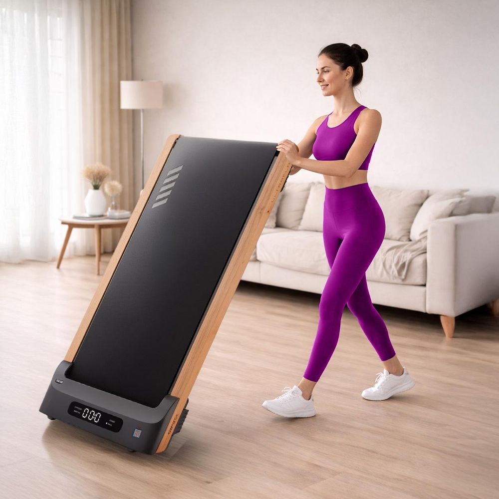 Frau rollt flaches Walking Pad mit Holzrahmen platzsparend im Wohnzimmer
