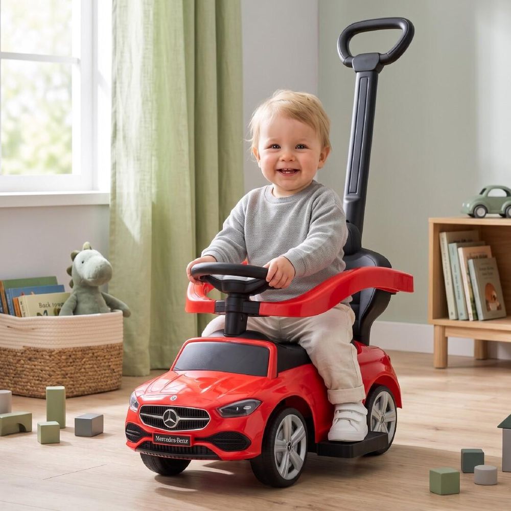 Enfant souriant sur le porteur Mercedes-Benz rouge à l'intérieur