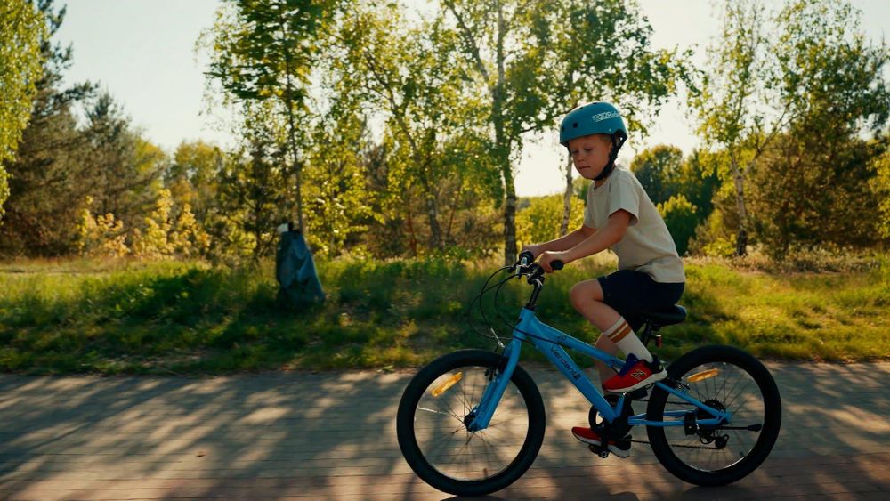Kind fährt das Fahrrad draußen auf einem Weg