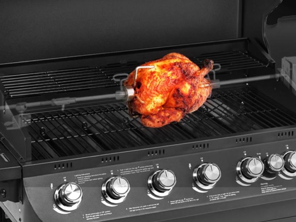 Grillhähnchen auf einem Grillspieß, der in die Grillspießauflage des  BRANDO 6+1 eingehangen ist