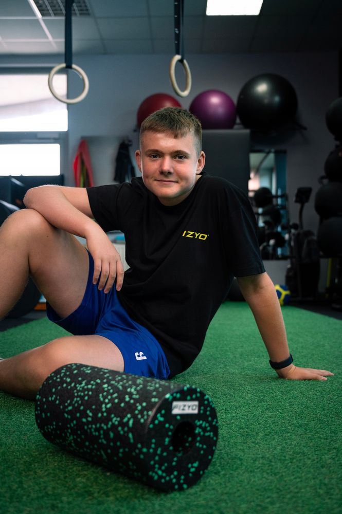 Training mit der FIZYO Massagerolle – Person führt Entspannungs- und Kräftigungsübungen durch.