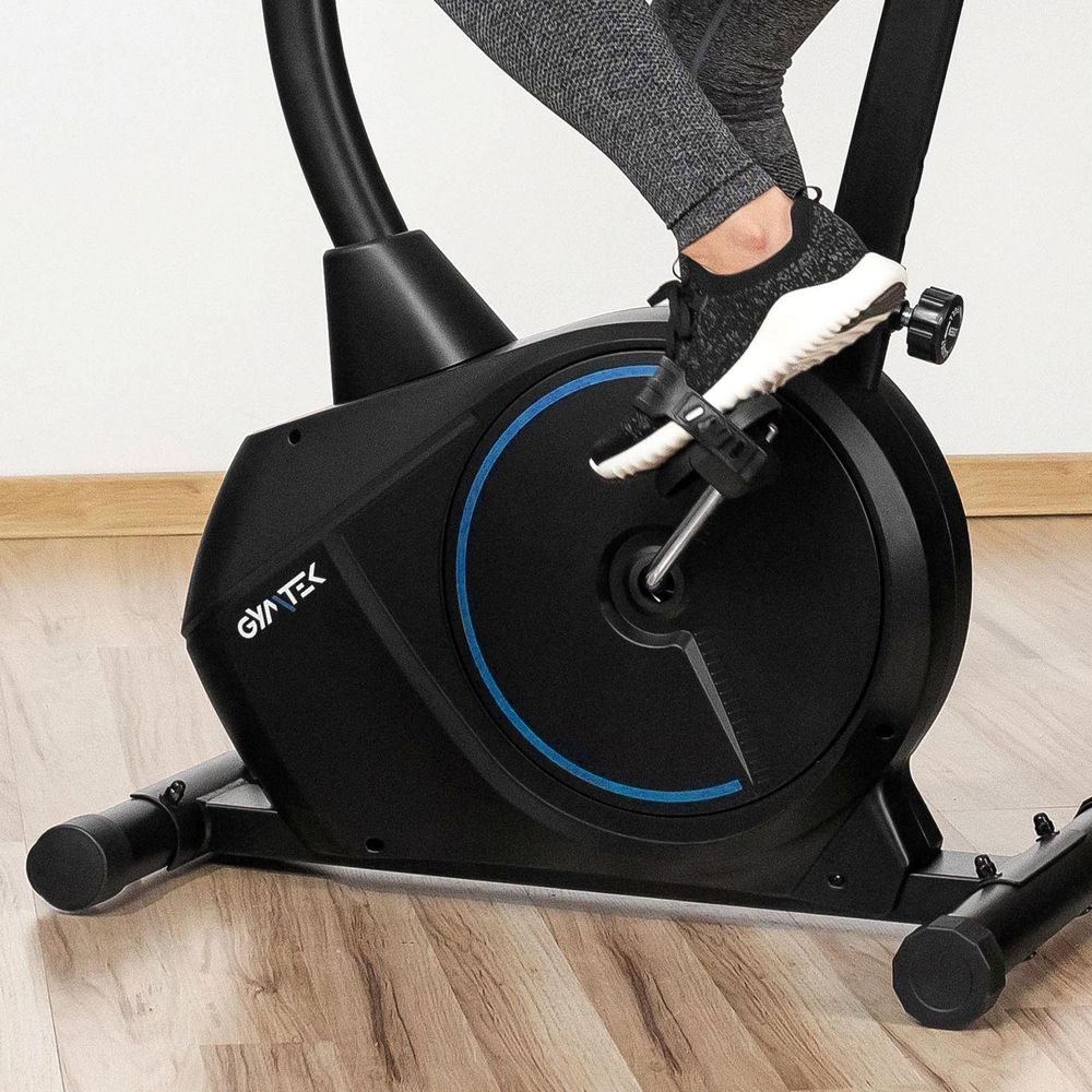 Nahaufnahme einer Person in Sportschuhen beim Treten des Pedals des schwarzen Heimtrainers
