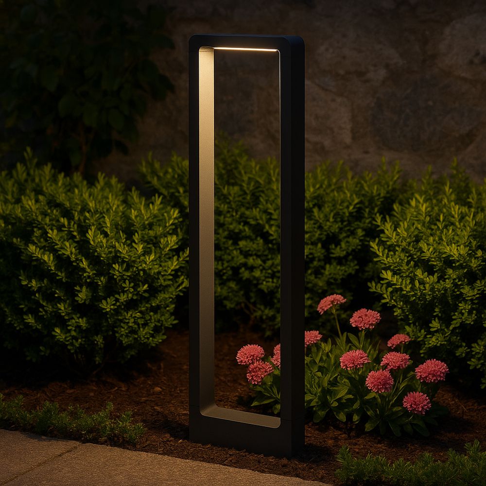 Schwarze LED Gartenleuchte beleuchtet Blumenbeet bei Nacht.