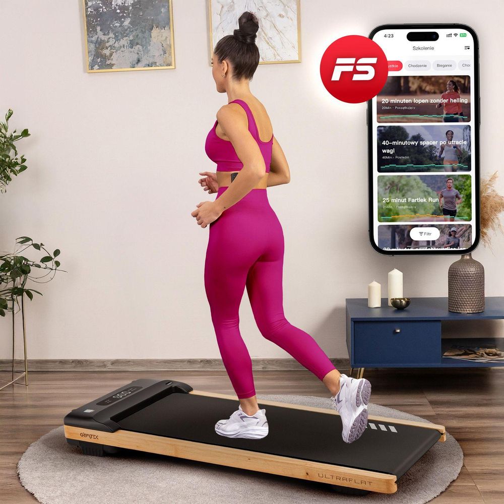 Frau trainiert auf dem Walking Pad mit FitShow App auf einem Smartphone-Display