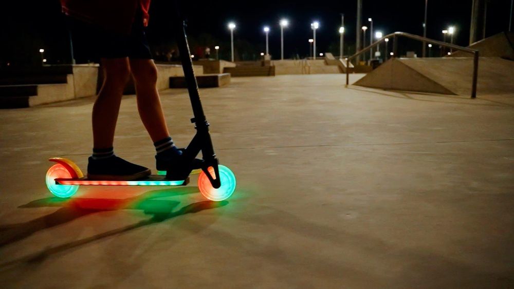 Kind rijdt op step met verlichte wielen en gebruikt de voetrem.