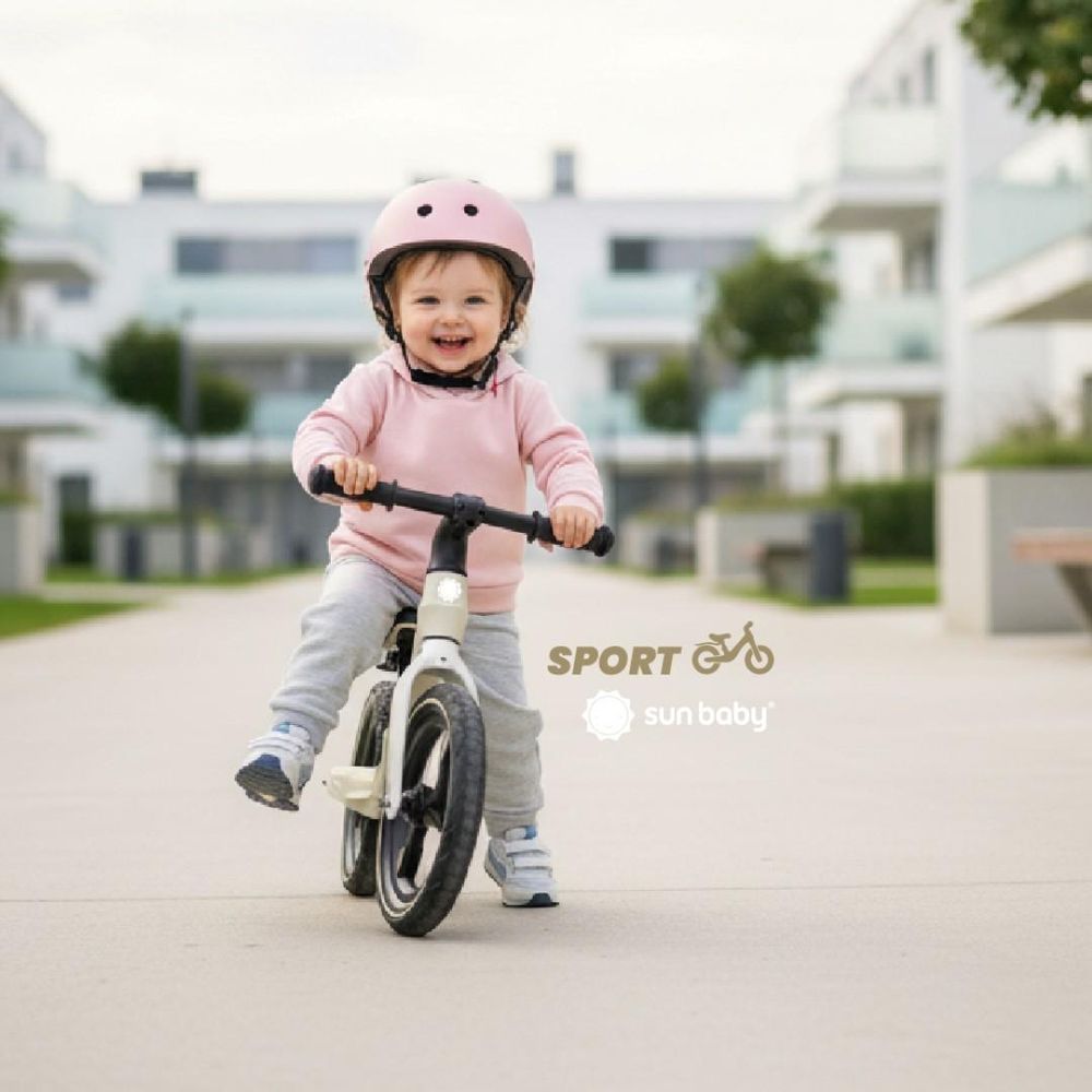 Dziecko jadące na rowerku Sun Baby SPORT 12" z przodu, uśmiechnięte.