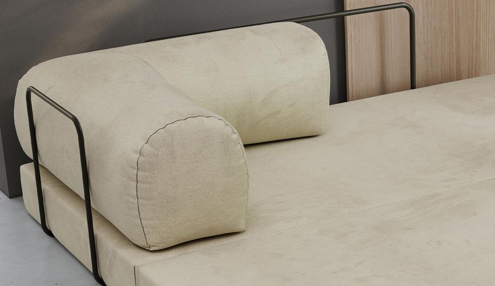Detailansicht eines beigen Sofas mit runden Kissen und schwarzem Metallrahmen.